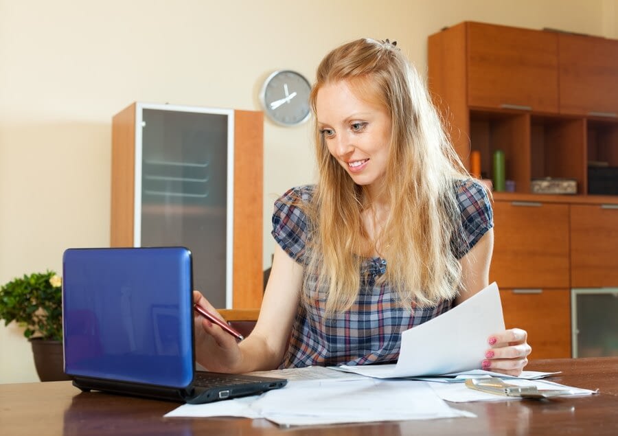 positive long haired woman working with documents laptop